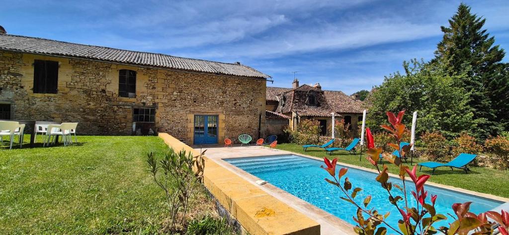 un jardin avec une piscine en face d'un bâtiment dans l'établissement Ideal Family - 45min from Sarlat- Swimming pool - WIFI, à Montferrand-du-Périgord