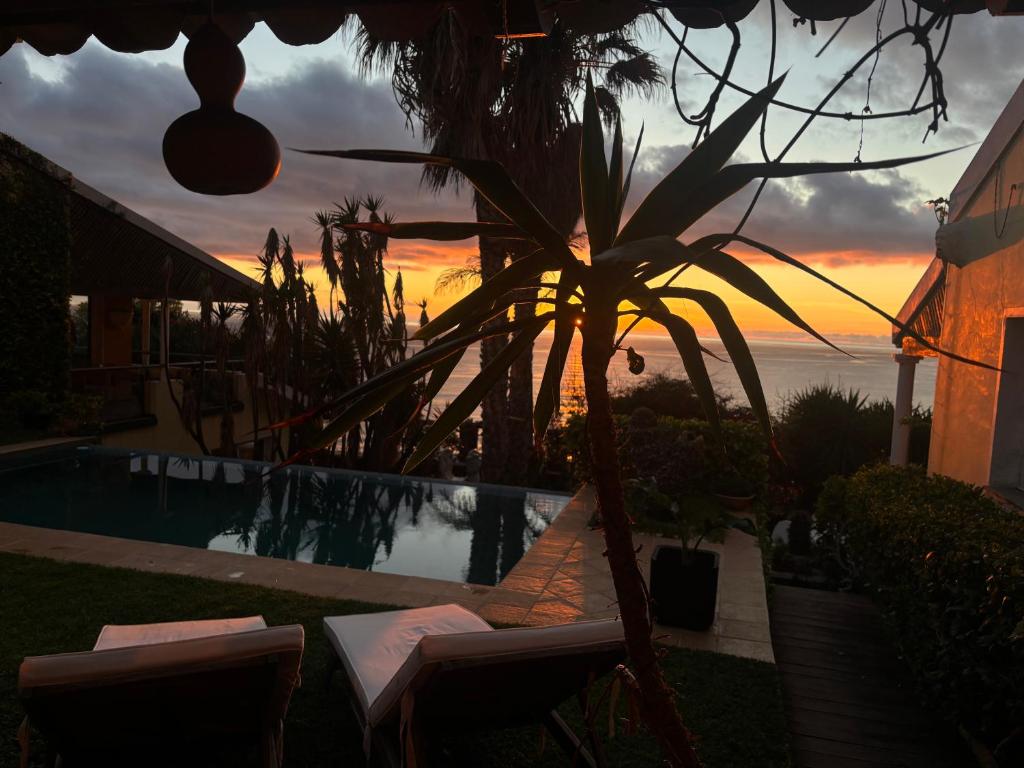 a view of a pool with a sunset in the background at Suite Bela Vigia 4 in Jardim do Mar