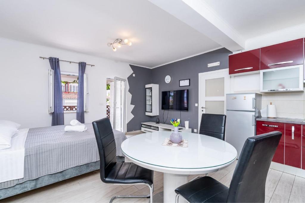 Una cocina y un comedor con una mesa y sillas blancas. en Studio Apartment Feather, en Dubrovnik