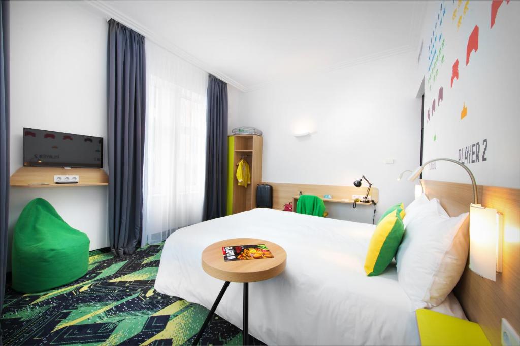 a hotel room with a bed and a table at Ibis Styles Budapest Center in Budapest