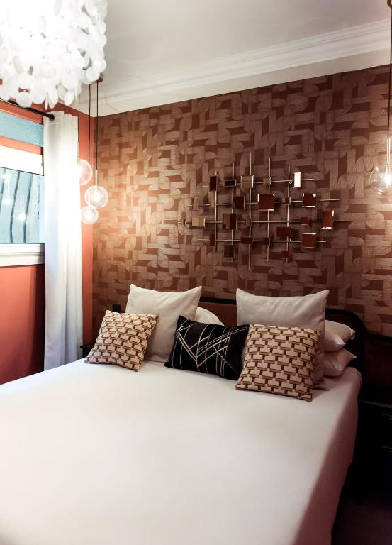 a bedroom with a large white bed and a brick wall at La Caravelle in Aix-en-Provence