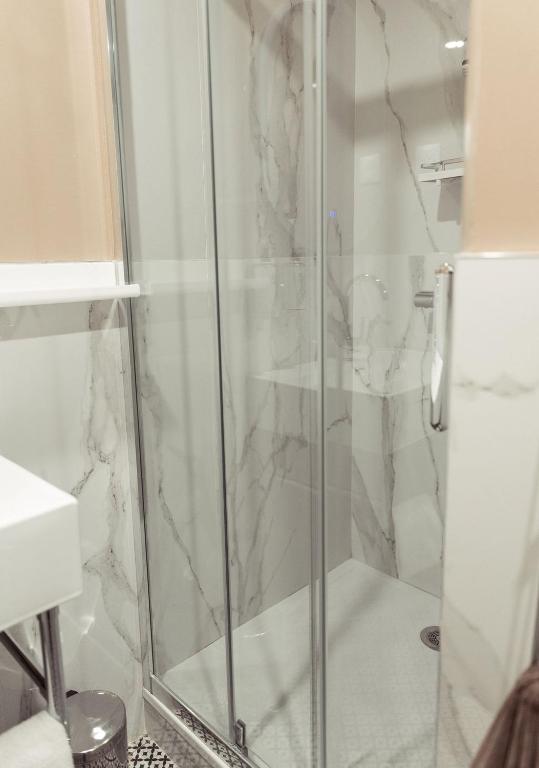 a shower with a glass door in a bathroom at La Caravelle in Aix-en-Provence