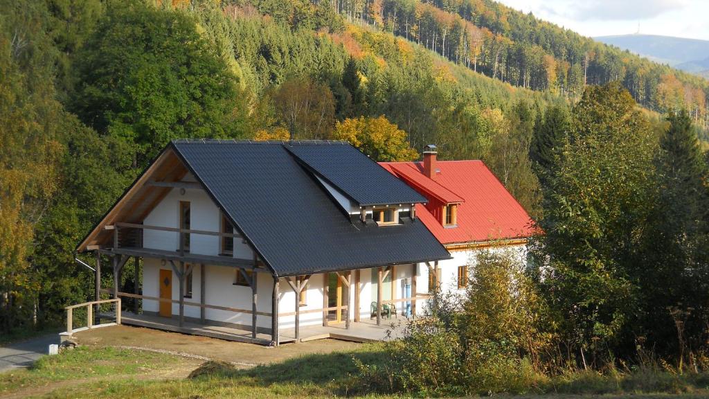 dom z czerwonym dachem na górze w obiekcie Apartments Světluška w mieście Loučná nad Desnou