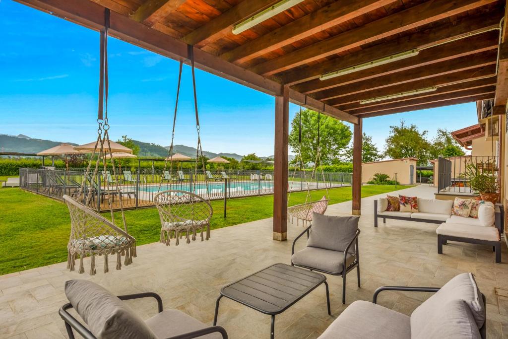 an outdoor patio with chairs and a swing at VISTALAGO VERSILIA in Massarosa