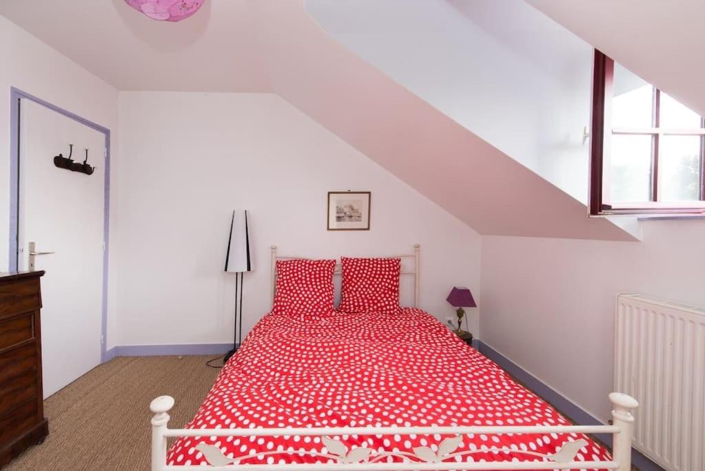 - une chambre blanche avec un lit rouge et des oreillers rouges dans l'établissement Maison Bleu, à Honfleur