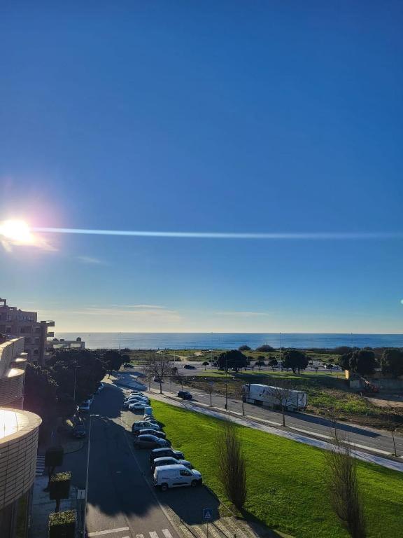 a view of a street with cars parked in a parking lot at Tertúlias com as ondas, T2 in Vila do Conde