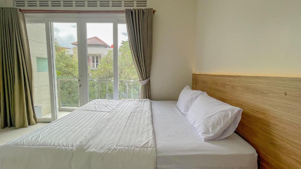 a bed in a room with a large window at AIVY Living by AIVY ID Official in Bandung