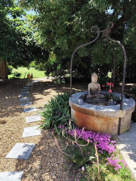 une statue assise dans une fontaine dans un jardin dans l'établissement Gîte de charme, à Arles