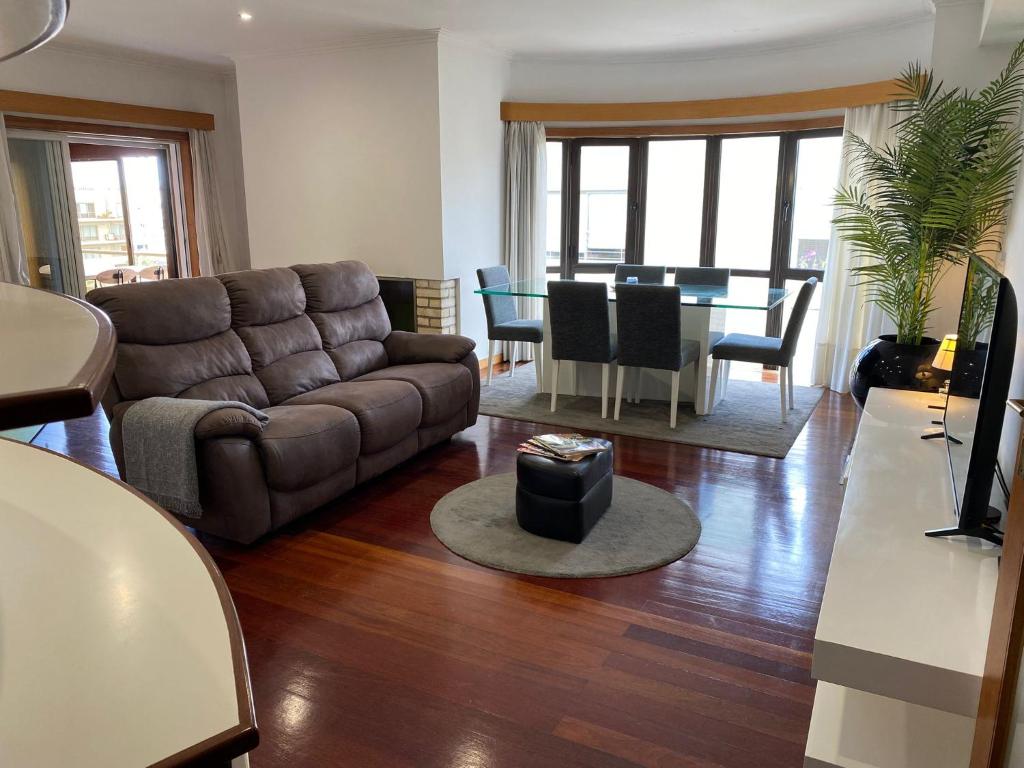 a living room with a couch and a dining room at Tertúlias com as ondas, T2 in Vila do Conde
