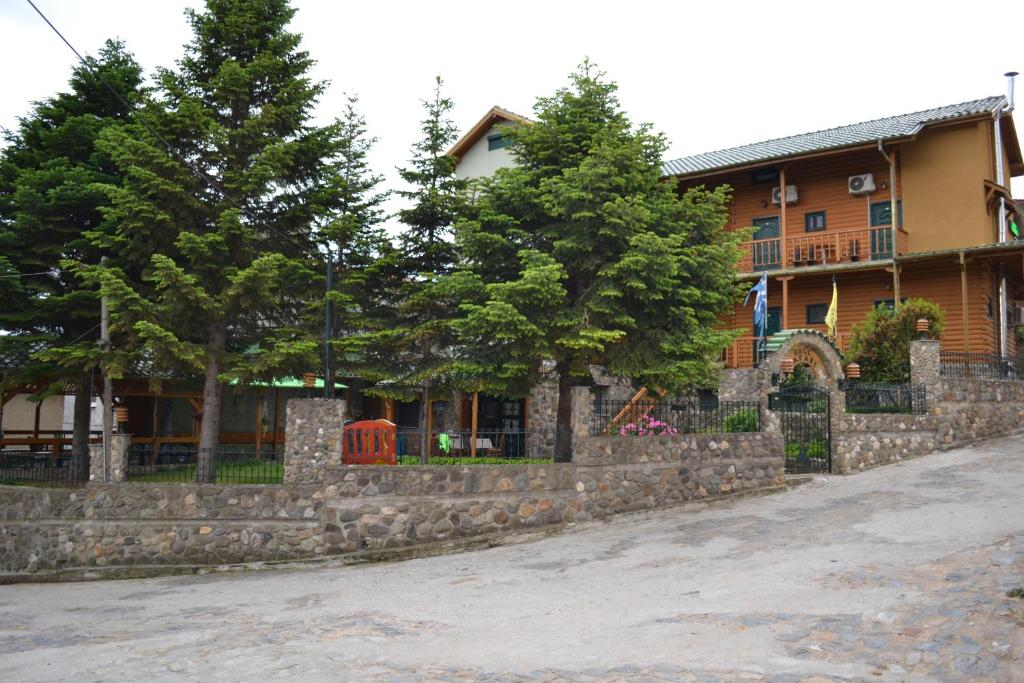 ein Haus mit einer Stützmauer aus Stein und Bäumen in der Unterkunft Chalet Safari in Aisími