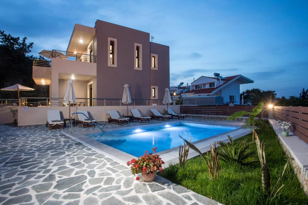 a villa with a swimming pool in front of a house at Oasis Luxury Villa in Rhodes Town