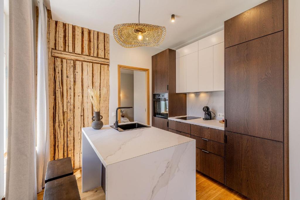a kitchen with a white counter and wooden cabinets at Freinholdi Maja külaliskorter 1 - with sauna in Võru
