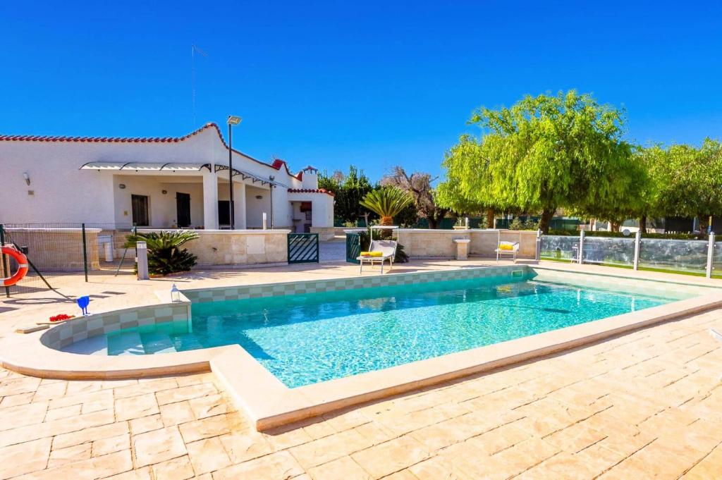 a swimming pool in a yard with a house at Villa Aranceto by Villa Plus in San Vito dei Normanni
