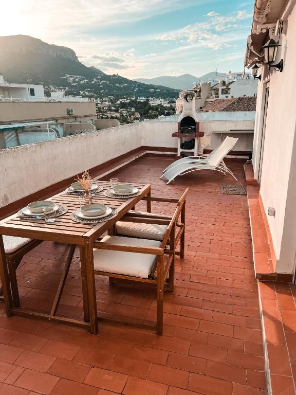 a wooden table and chairs on a balcony at Rooftop 24 in Calpe