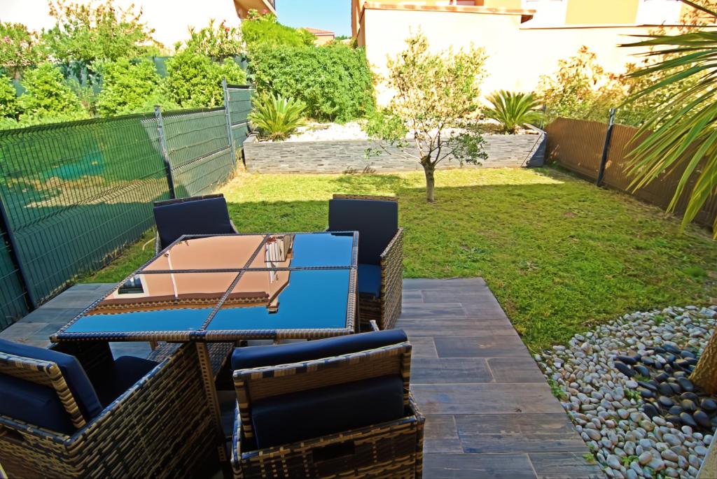 d'une terrasse avec des chaises et une table dans la cour. dans l'établissement Charmante maison de ville avec jardin, à Montélimar