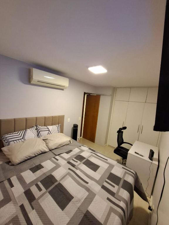 a bedroom with a bed and a chair in it at Asa Norte - Suíte Premium - Conforto e praticidade in Brasília