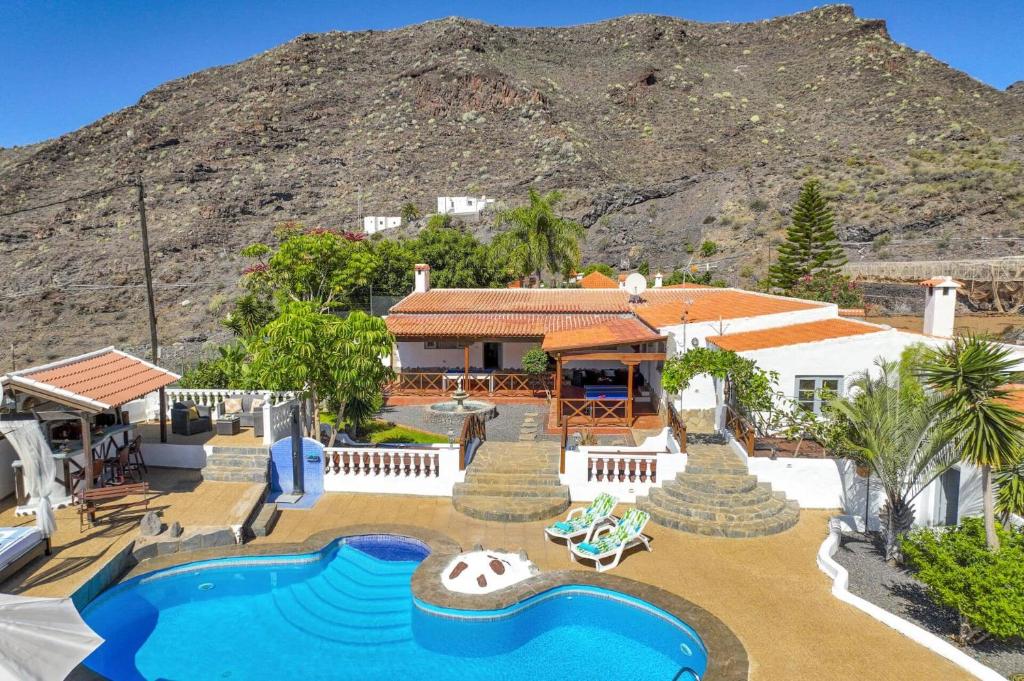 una casa con piscina di fronte a una montagna di Villa Colmena by Villa Plus a Guía de Isora