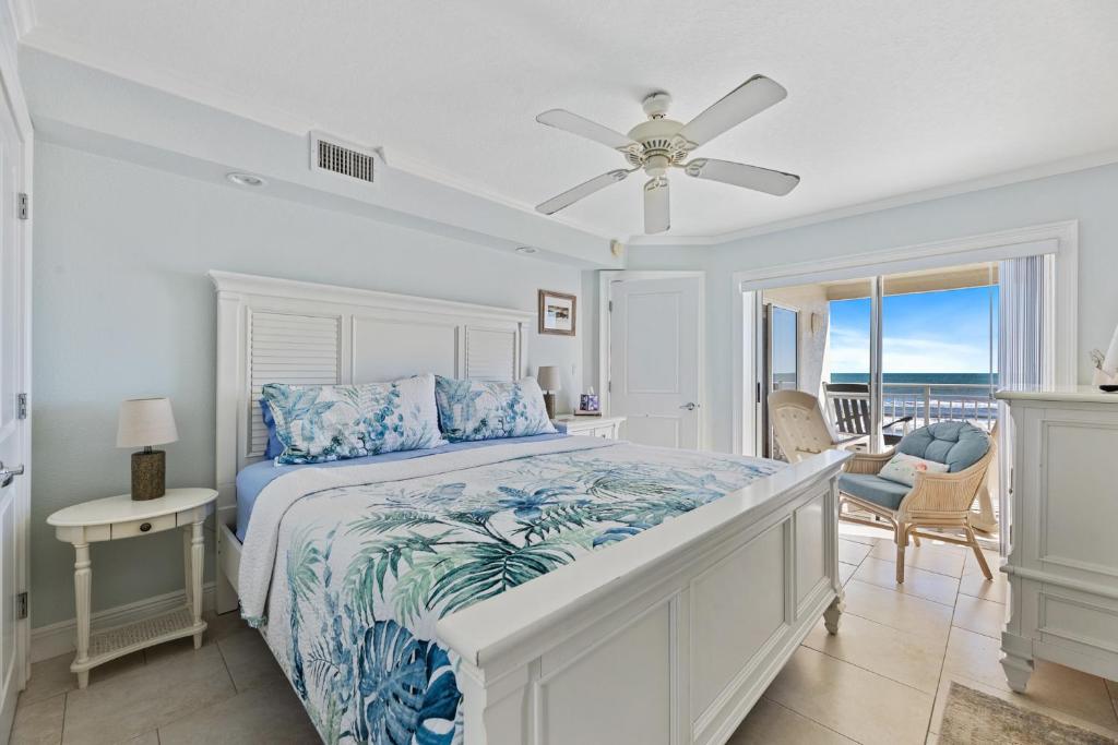 a bedroom with a bed and a ceiling fan at Palm House 3B with oceanfront views, pool, and private beach access in New Smyrna Beach