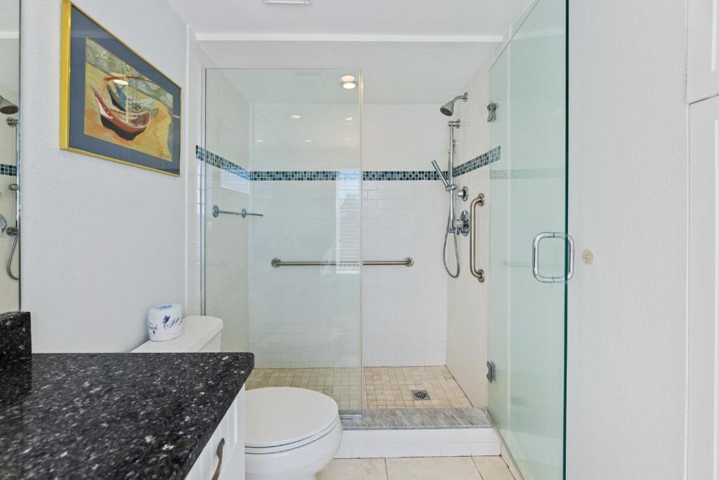 a bathroom with a shower and a toilet at Palm House 3B with oceanfront views, pool, and private beach access in New Smyrna Beach