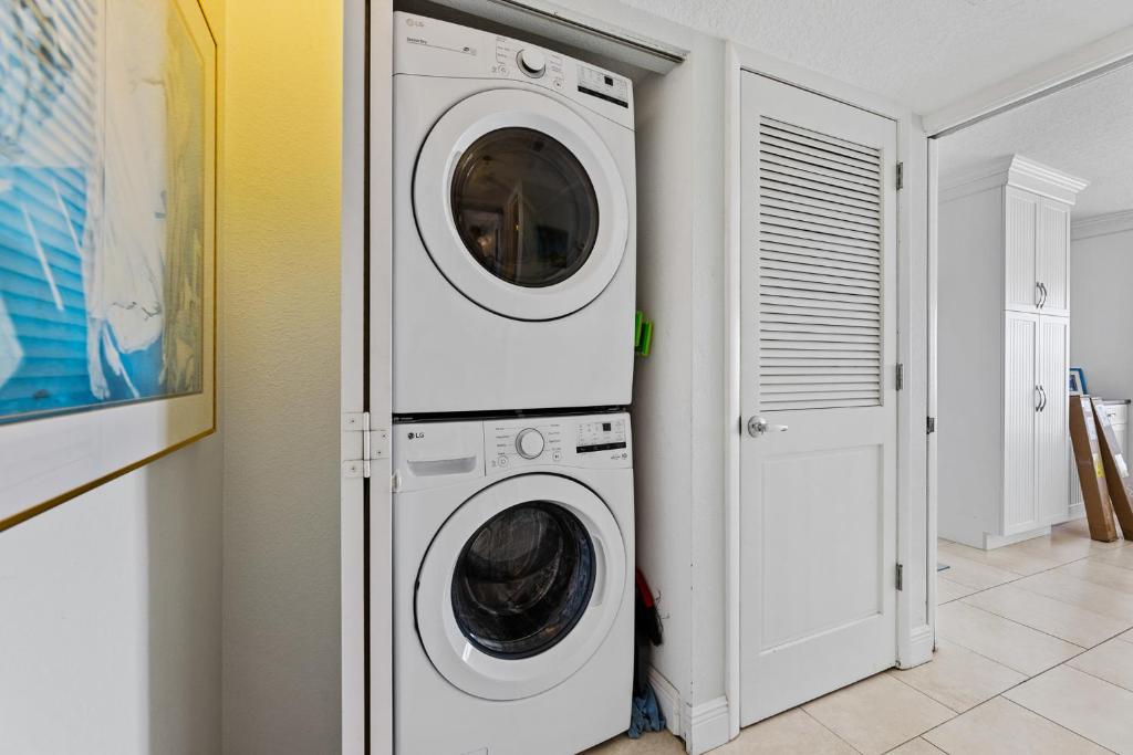 a white washer and dryer in a room at Palm House 3B with oceanfront views, pool, and private beach access in New Smyrna Beach