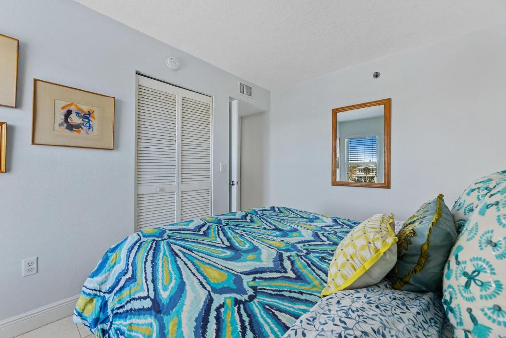 a bedroom with a couch and a mirror at Palm House 3B with oceanfront views, pool, and private beach access in New Smyrna Beach