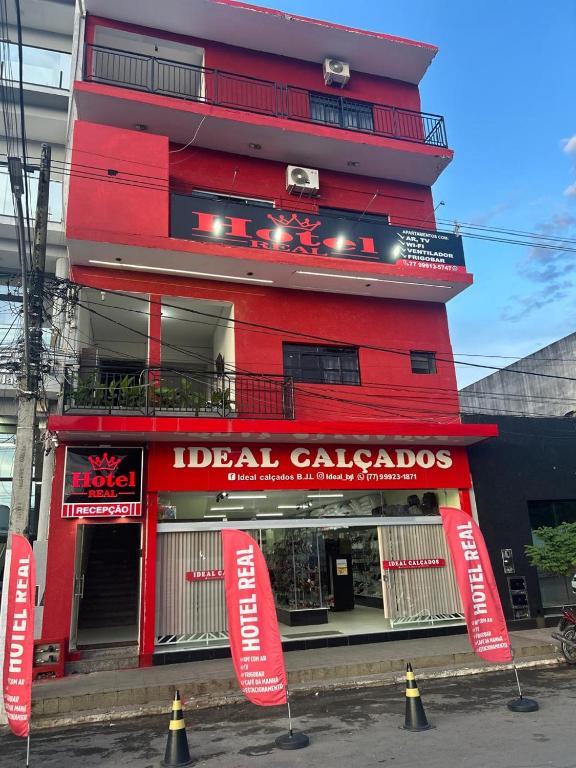 a red building with signs in front of it at Hotel Real in Bom Jesus da Lapa