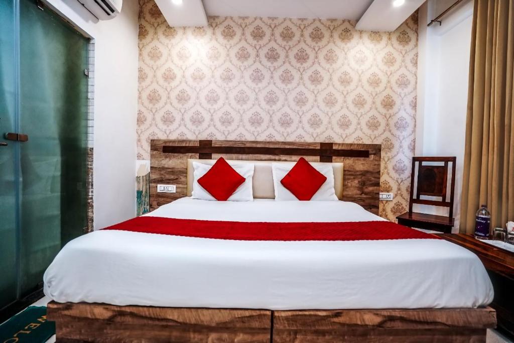 a bedroom with a large bed with red pillows at HOTEL Le GRAND in Jāmb