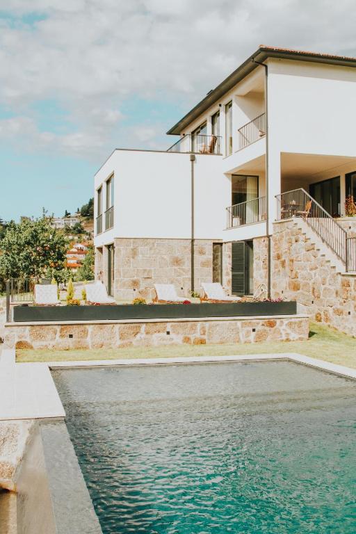 a house with a swimming pool in front of a house at Quinta D'Joanes Douro in Resende