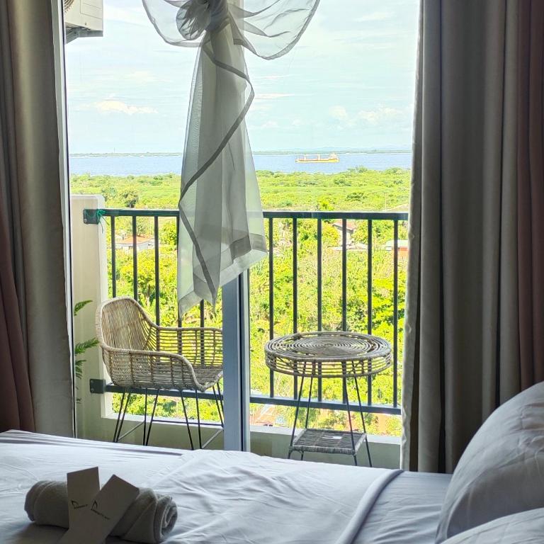 a bedroom with a bed and a balcony with a view at Adam&Eva Condo Staycation in Lapu Lapu City