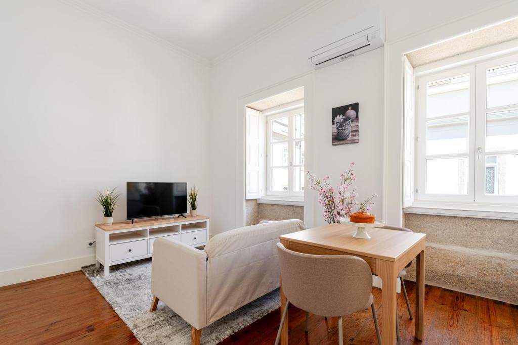 a living room with a couch and a tv and a table at Bright Flat in Historic Foz House by HostWise in Porto