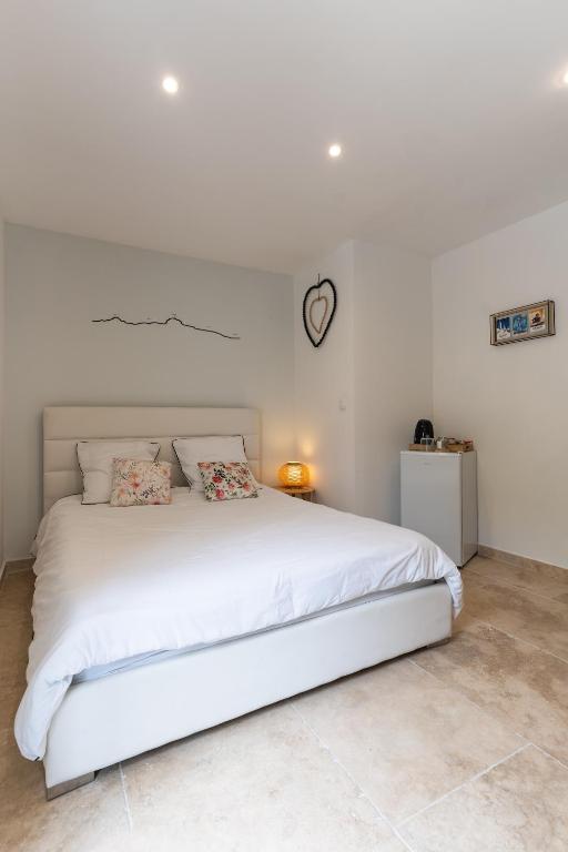 - une chambre blanche avec un grand lit blanc dans l'établissement La Chambre de Mijeane, à Gémenos