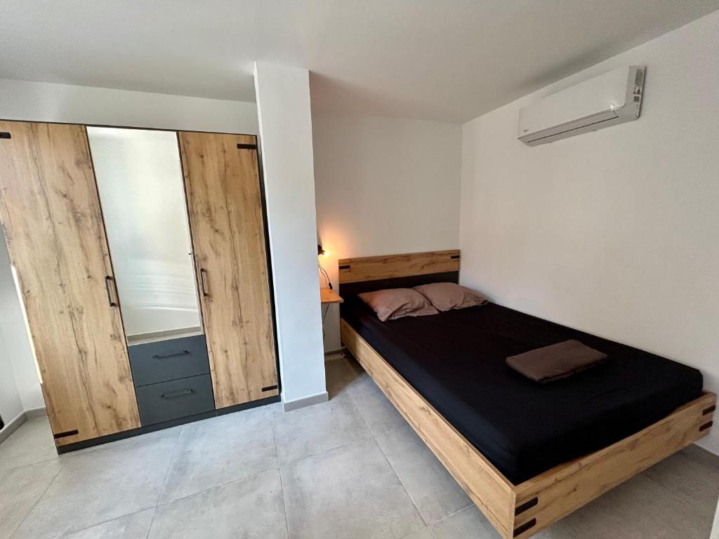 - une petite chambre avec un lit et un grand miroir dans l'établissement 2 Minutes du Centre Historique - T3 en RDC, à Avignon