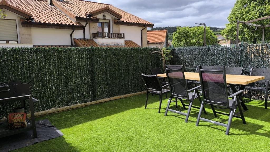 a table and chairs on the grass in a backyard at Casa Valles Verdes in Reocín