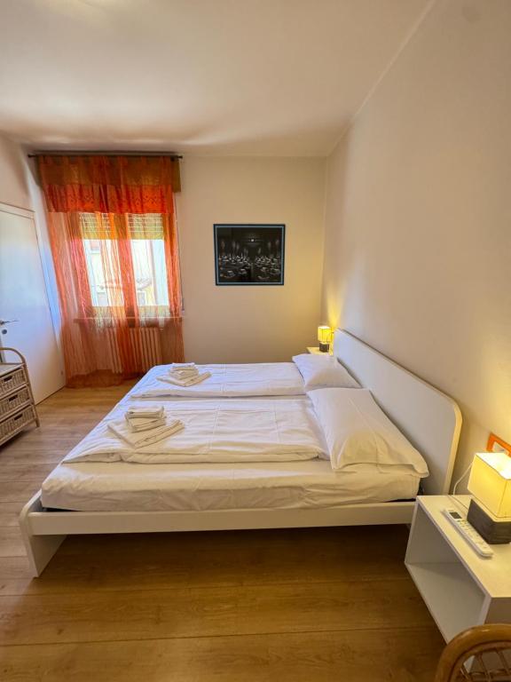 a bedroom with a large white bed in a room at Residenza Bouganville in Torri del Benaco
