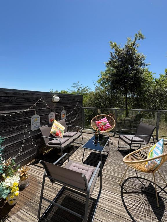 a patio with chairs and tables on a wooden deck at Le Charmant des Coteaux, Free Parking & Free Wifi in Toulouse