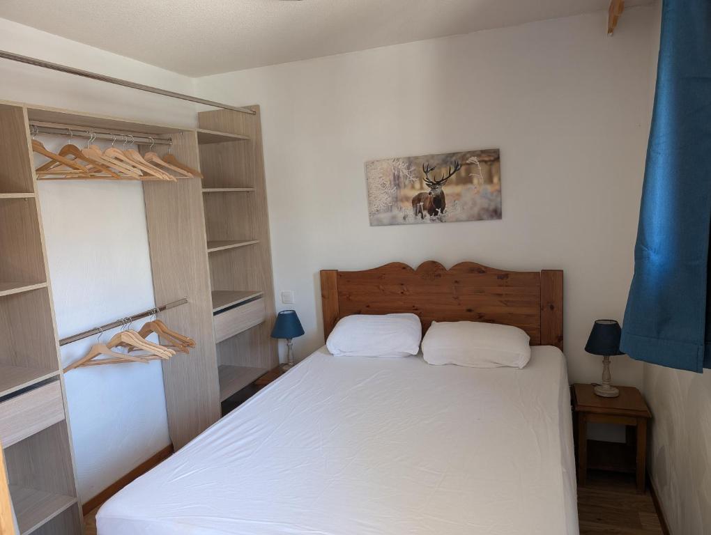 a bedroom with a white bed and shelves at Les Orres 1800 - 6 places Plein Sud avec Piscine in Les Orres