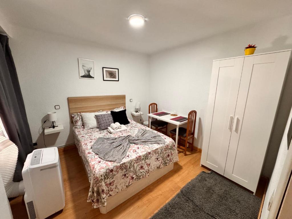 een kleine slaapkamer met een bed en een tafel bij Habitación interior en Madrid in Madrid