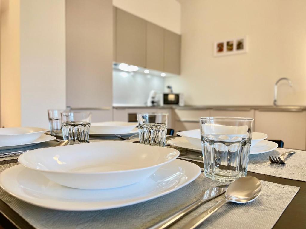 a table with plates and glasses on top of it at Cenisio 12 in Bergamo