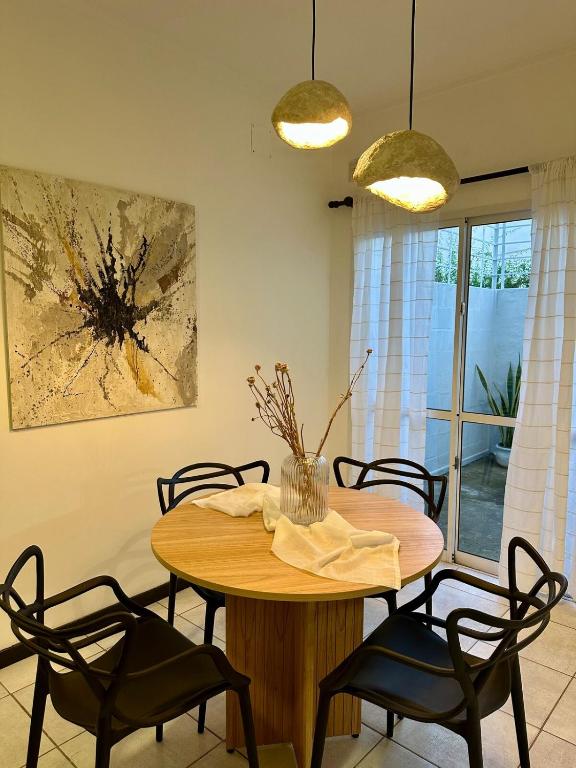 a dining room with a wooden table and chairs at Departamento Sol Urbano in Rafaela