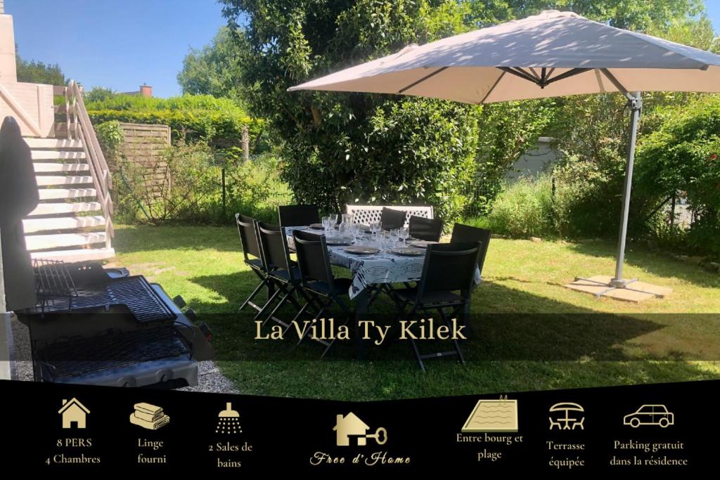 - une table avec un parasol dans la cour dans l'établissement Ty Kilek - entre bourg et plage, à Saint-Gildas-de-Rhuys