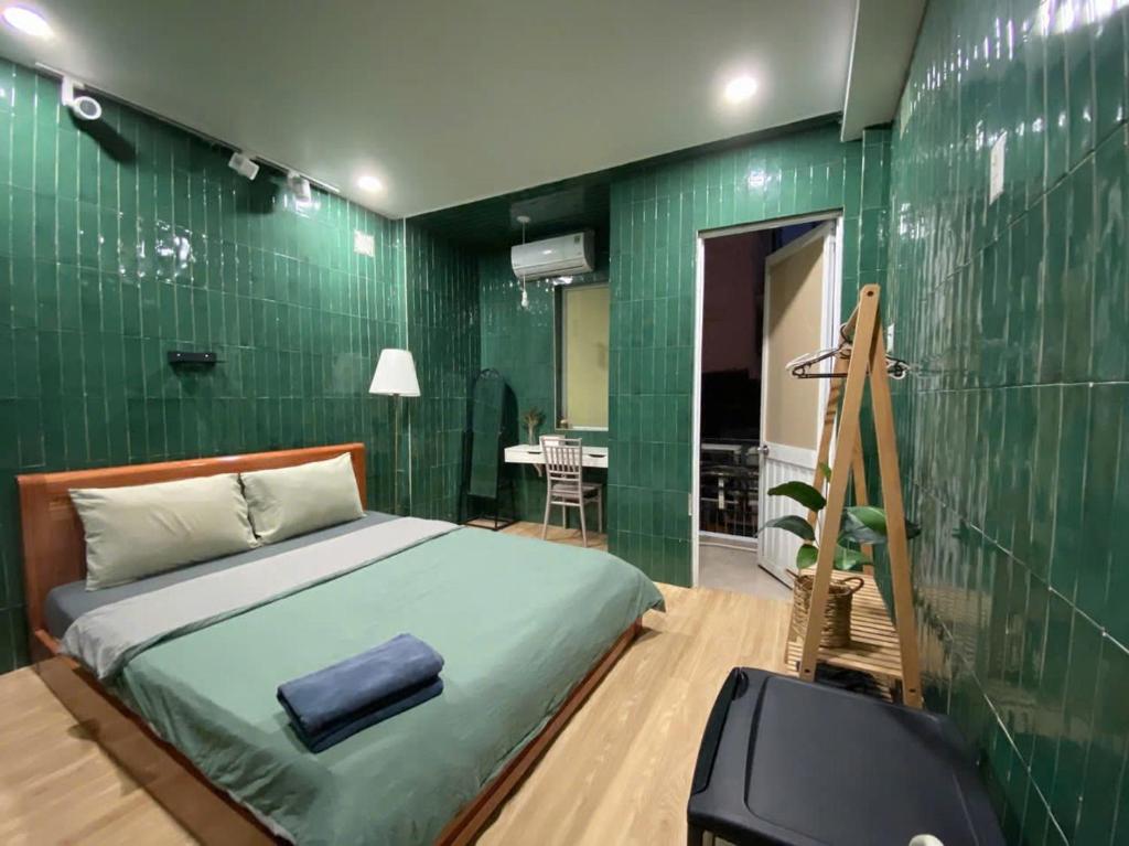 a bedroom with a bed and a green wall at PAPAYA HOTEL & Café 2 in Ho Chi Minh City