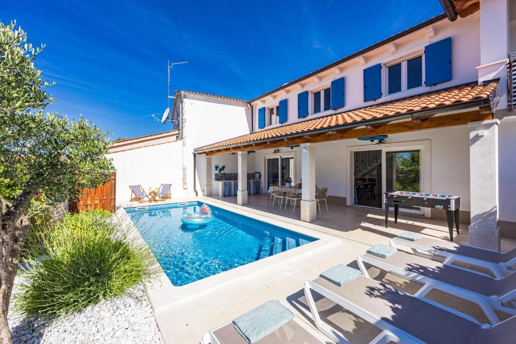 a villa with a swimming pool and lounge chairs at Villa Blue Istria in Burići