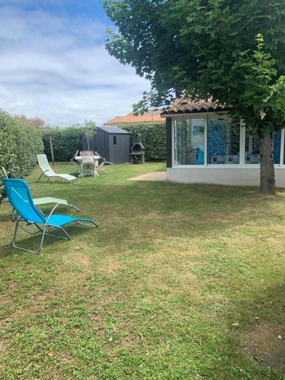 2 chaises et une table dans la cour dans l'établissement Entre mer et centre-ville, à La Tranche-sur-Mer