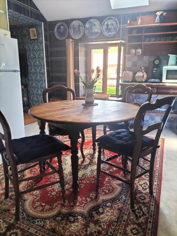 une cuisine avec une table en bois et deux chaises dans l'établissement Les Chanterelles La souris des champs, à Étival-Clairefontaine