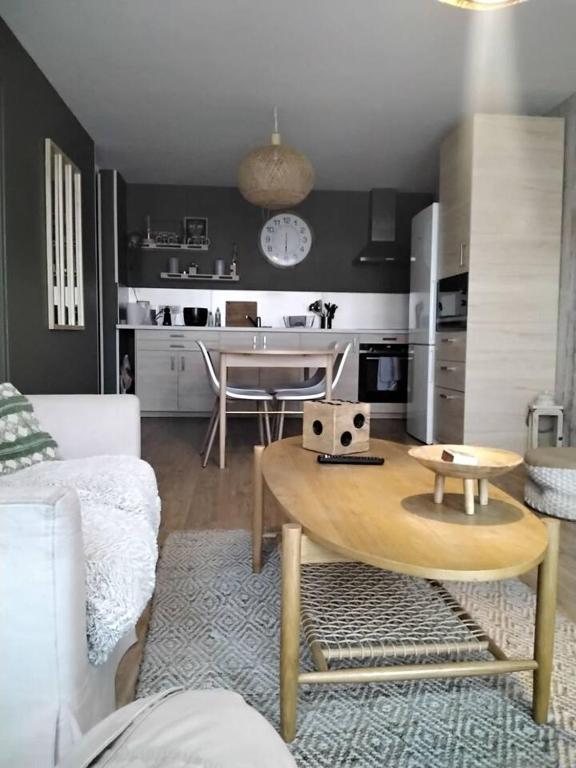 un salon avec une table et une cuisine dans l'établissement Appartement 4 chambres et 4 salles de bains, à Reims
