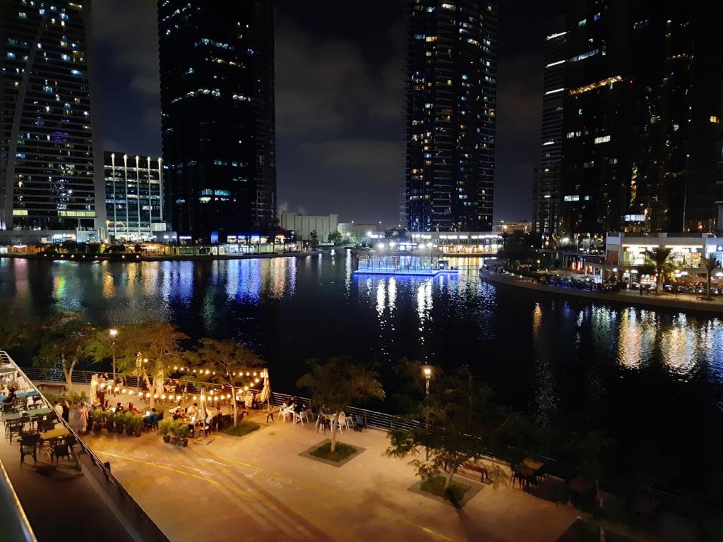 a view of a city at night with lights at Rustic Elegance By The Lake Studio Cabin In Jlt in Dubai