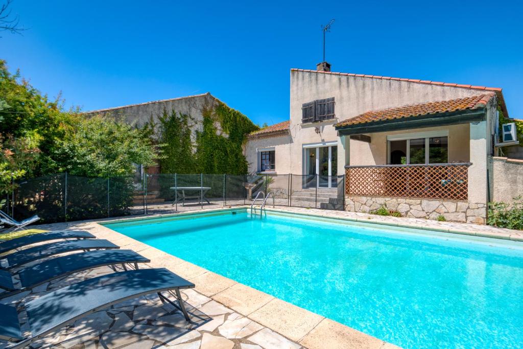 - une piscine avec des chaises en face d'une maison dans l'établissement Villa Montady avec piscine, à Montady