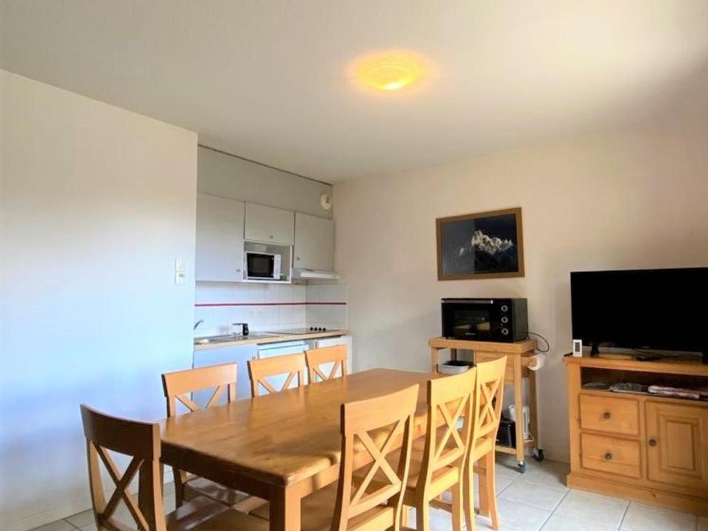 a kitchen and dining room with a wooden table and chairs at Chalet mitoyen 3 pièces 7 personnes avec piscine et sauna - Résidence Les Flocons du Soleil - FR-1-504-56 in Le Dévoluy