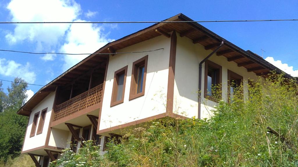 Casa blanca con techo de madera en Chepelare Holiday Guest House, en Chepelare