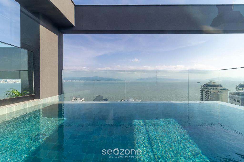 a swimming pool with a view of the ocean at Estadia tranquila e completa em prédio com piscina – VPD in Florianópolis